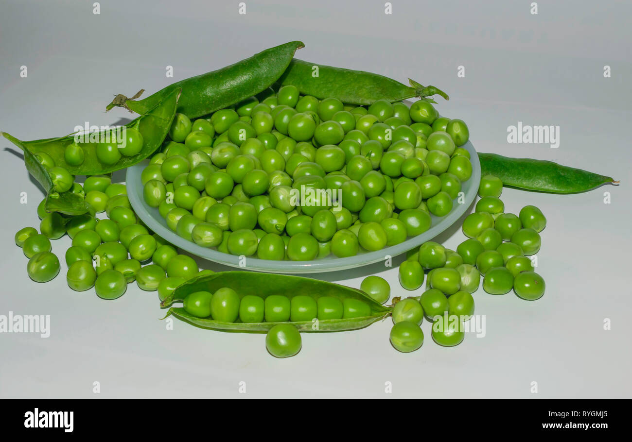 green pea pod,green peas in a white bowl,white background. Stock Photo