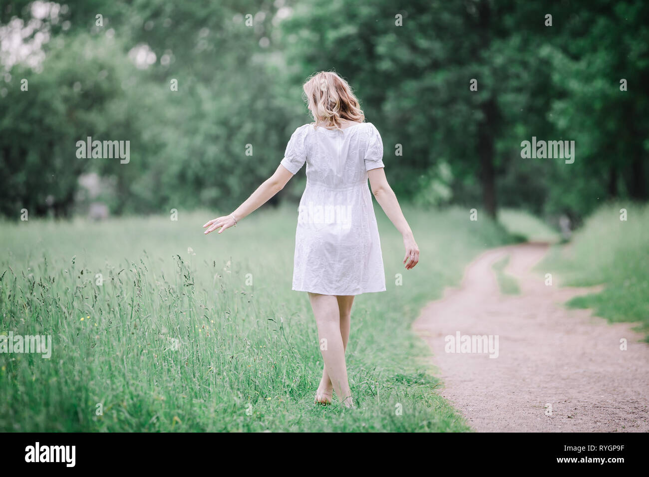 Woman walking barefoot on grass hi-res stock photography and images - Alamy