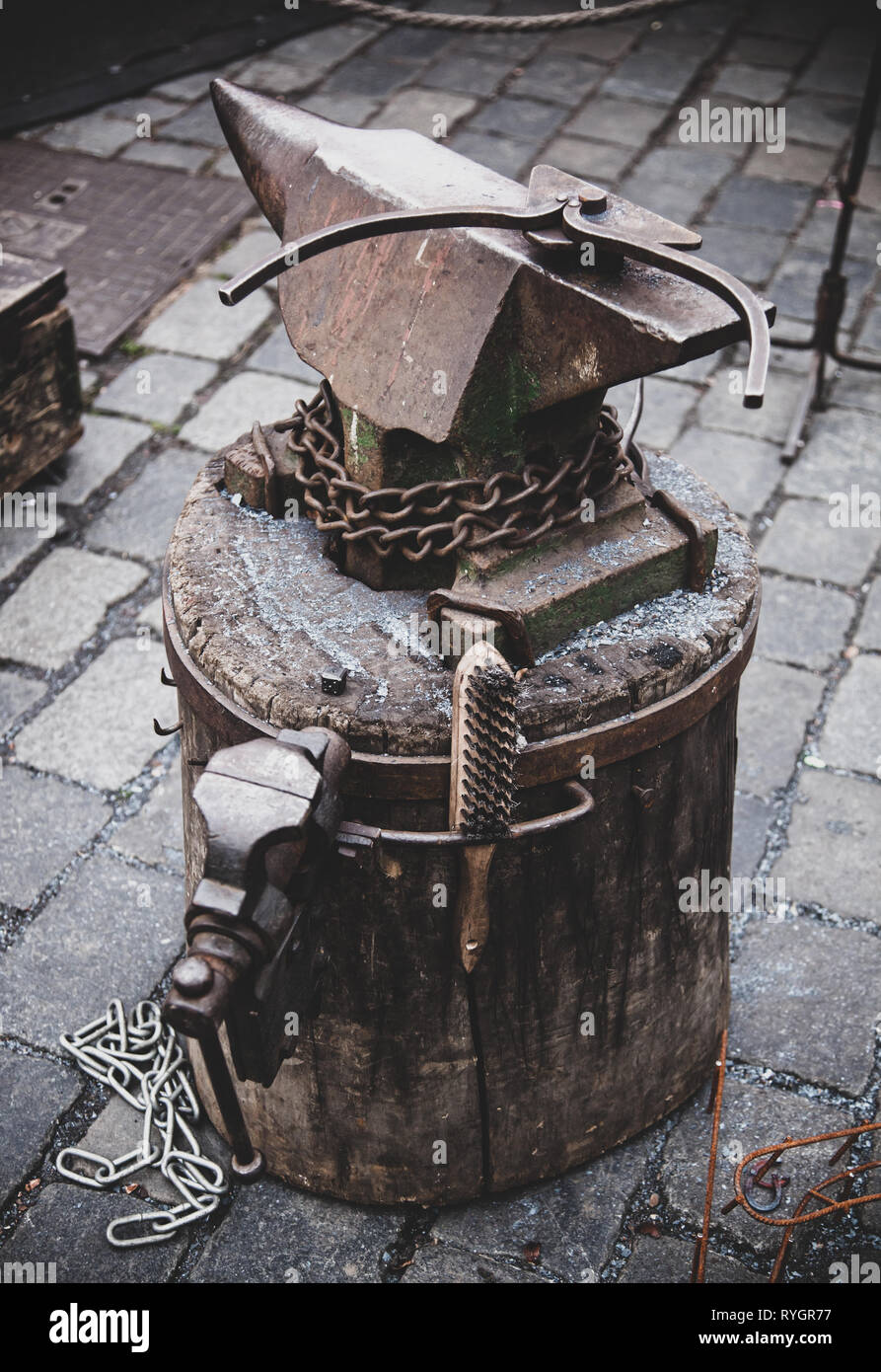 Authentic anvil of the blacksmith placed on a wooden block. Stock Photo