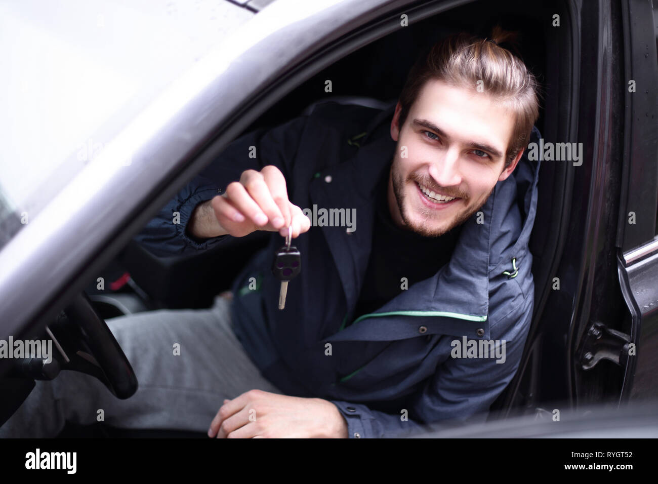 handsome young man showing the key of new car Stock Photo - Alamy