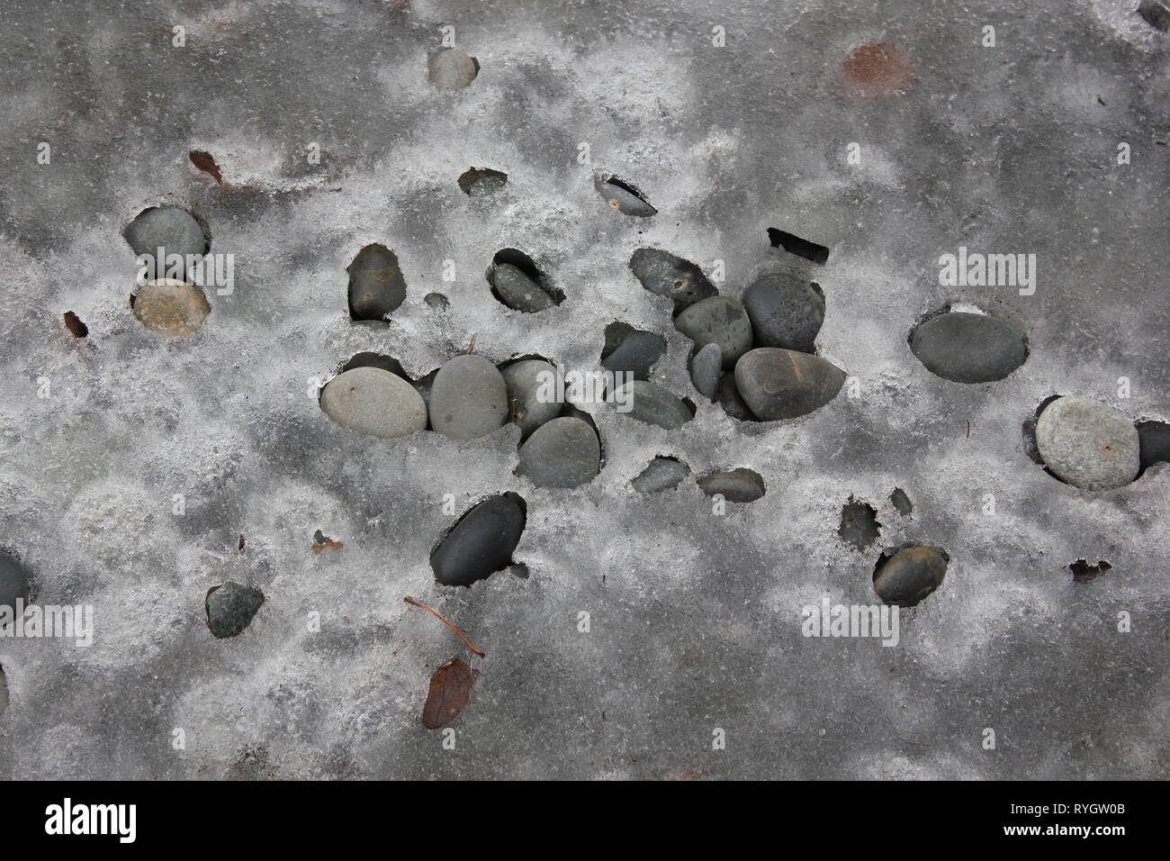 River rocks frozen in ice create a zen and and Feng shui effect. Stock Photo