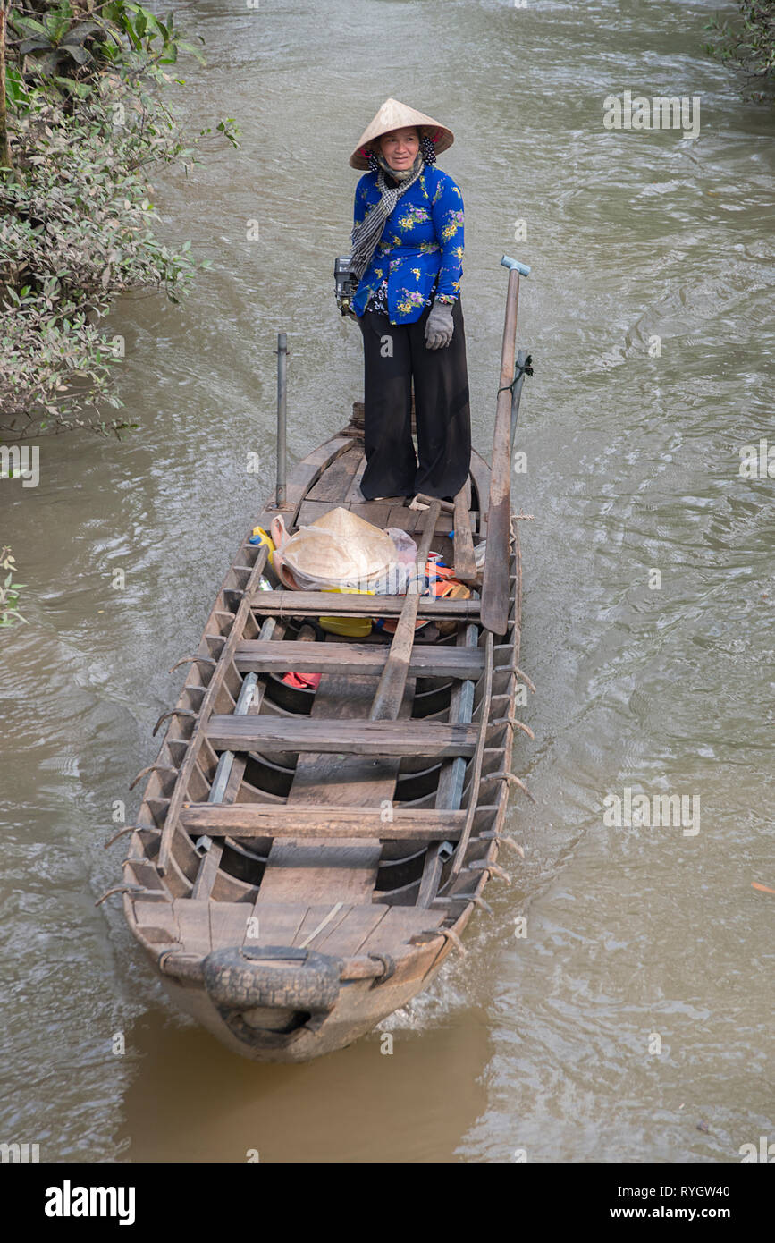 Lady steering boat on Cambodian waterway Stock Photo