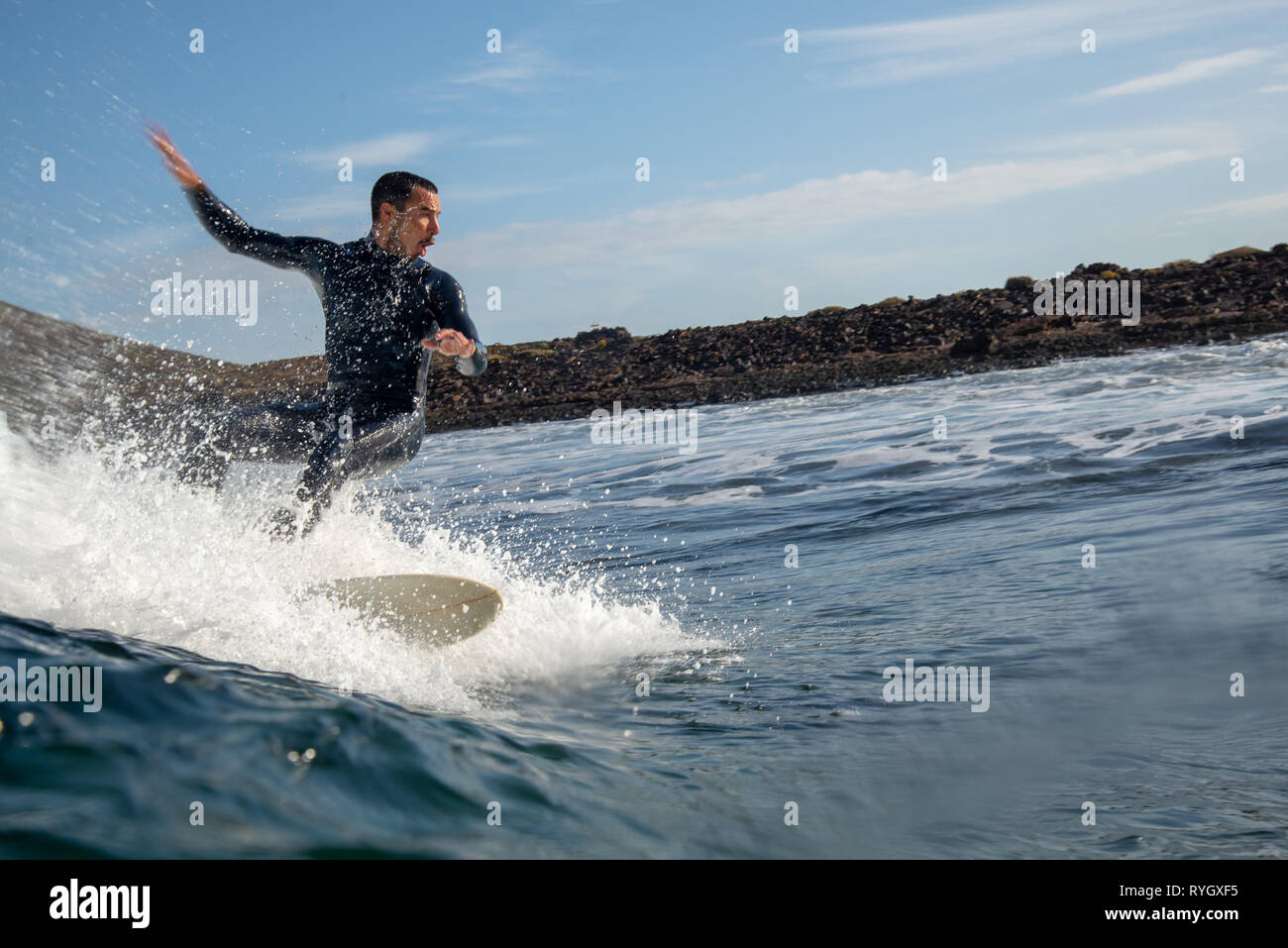 surfer riding waves on the island of fuerteventura in the Atlantic Ocean Stock Photo
