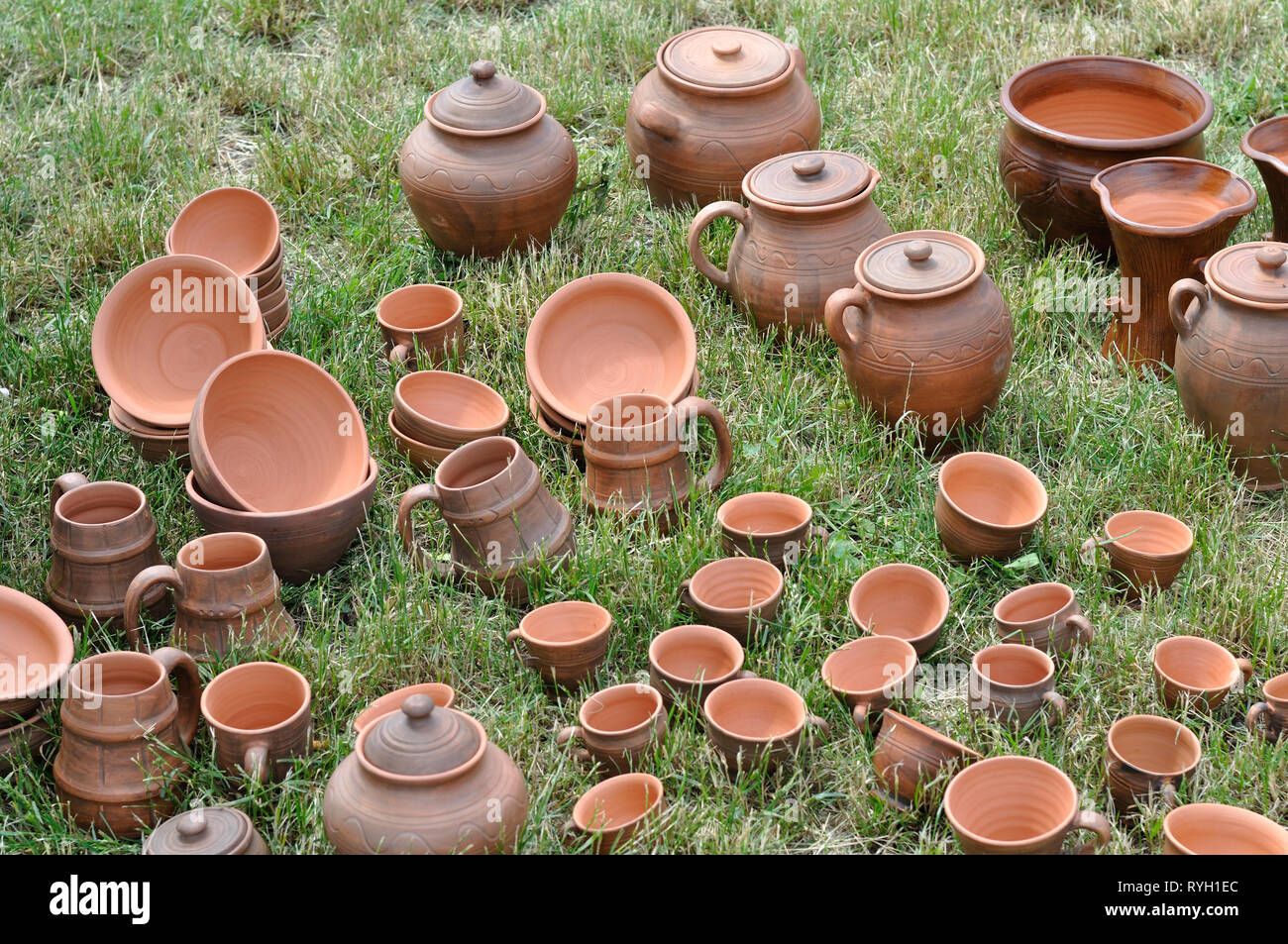 Lots of traditional ukrainian handmade clay pottery production on the green grass Stock Photo
