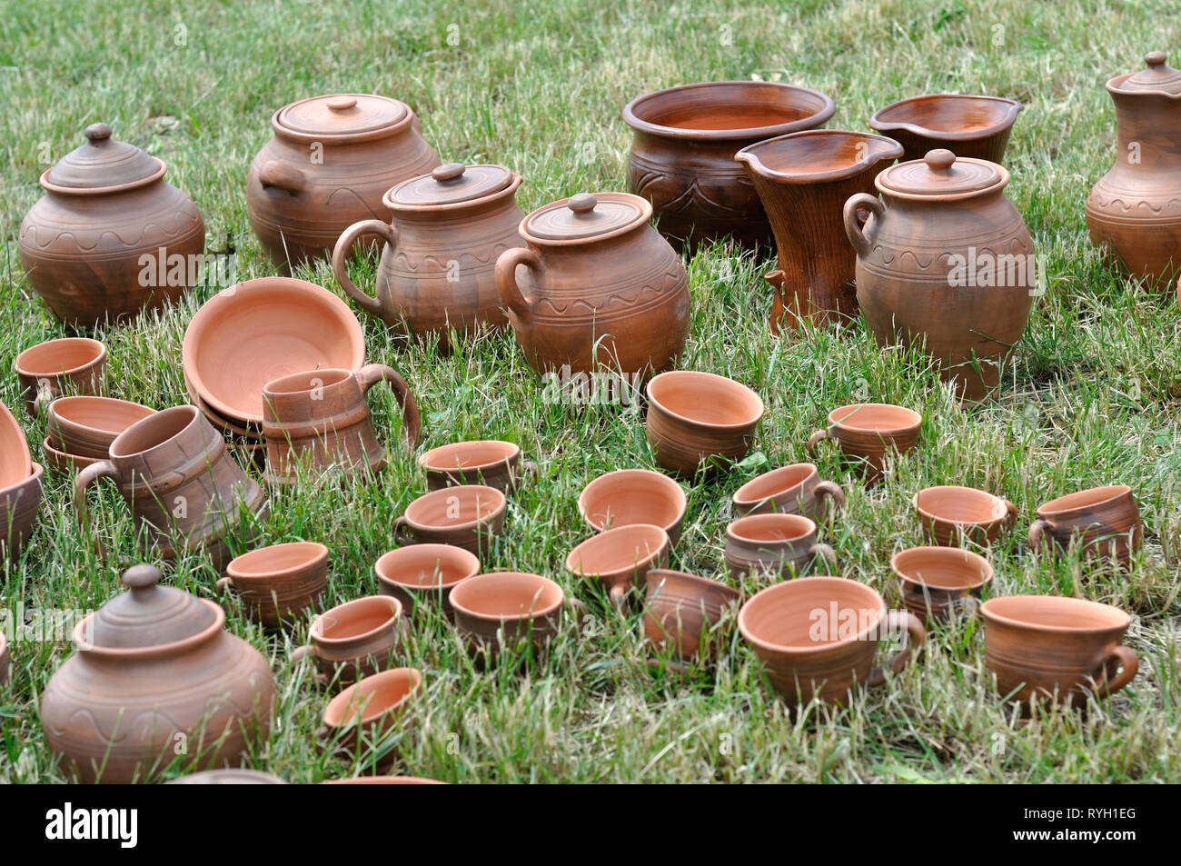 Lots of traditional ukrainian handmade clay pottery production on the green grass Stock Photo