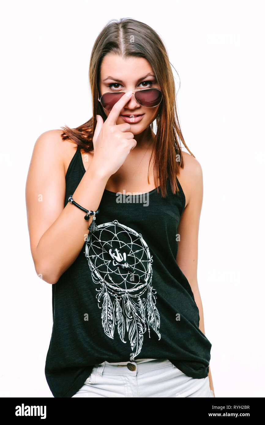 Pretty young girl touching her brown sunglasses in black armless shirt Stock Photo