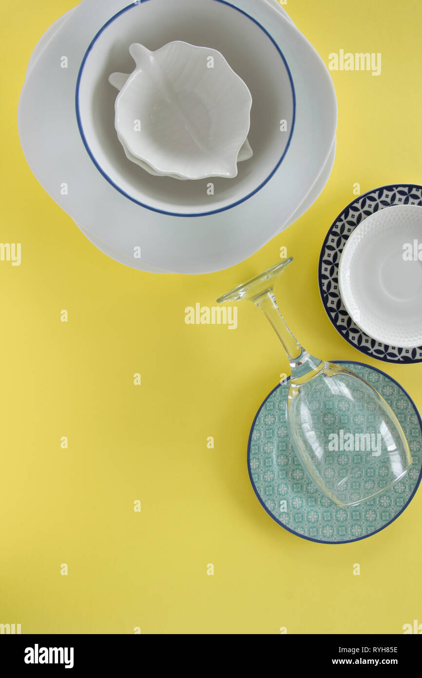 Different porcelain tableware on fresh yellow background Stock Photo ...