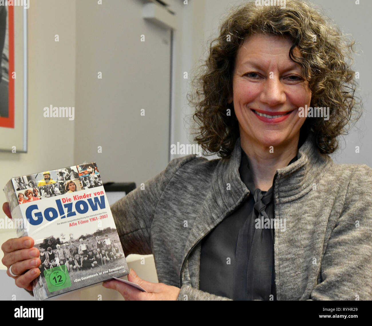 14 March 2019, Brandenburg, Potsdam: Ursula von Keitz, director of the  Filmmuseum Potsdam, holds the DVD edition of all films "Children of Golzow"  in her hands. The director couple Junge have handed