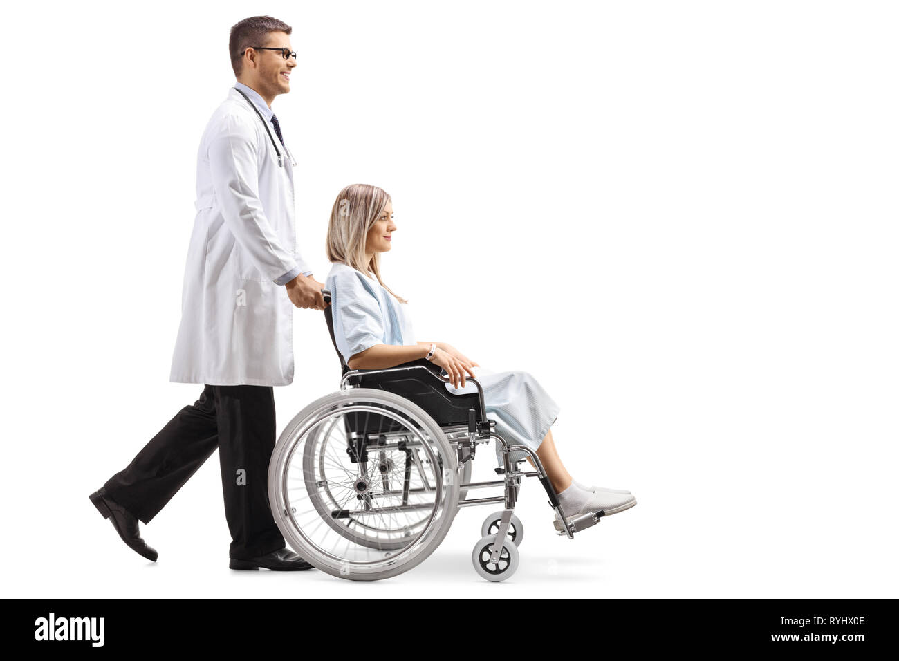 Full length shot of a young male doctor pushing a woman in a wheelchair isolated on white background Stock Photo