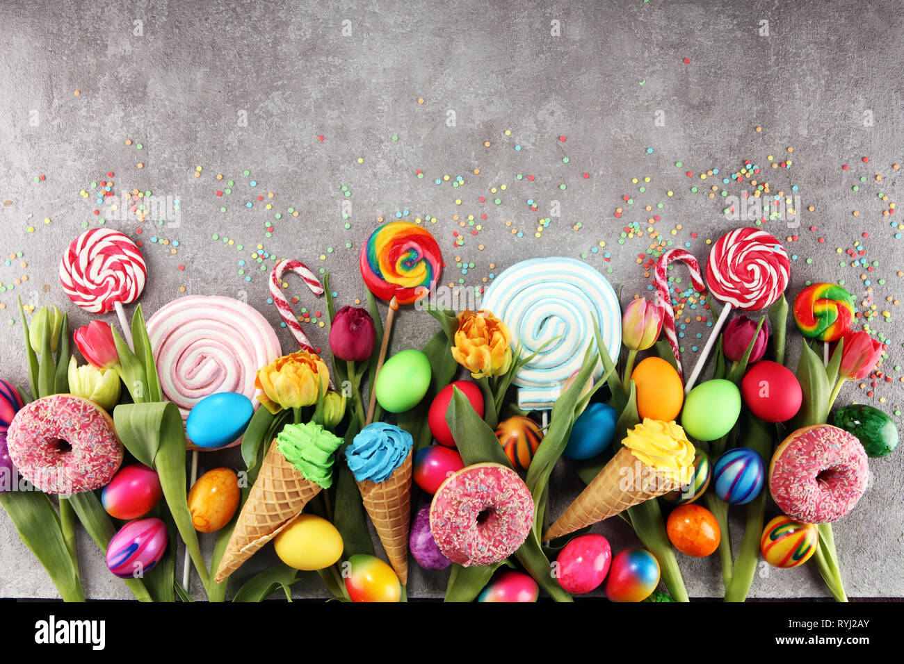 candies with jelly and sugar with tulips and easter eggs. colorful ...