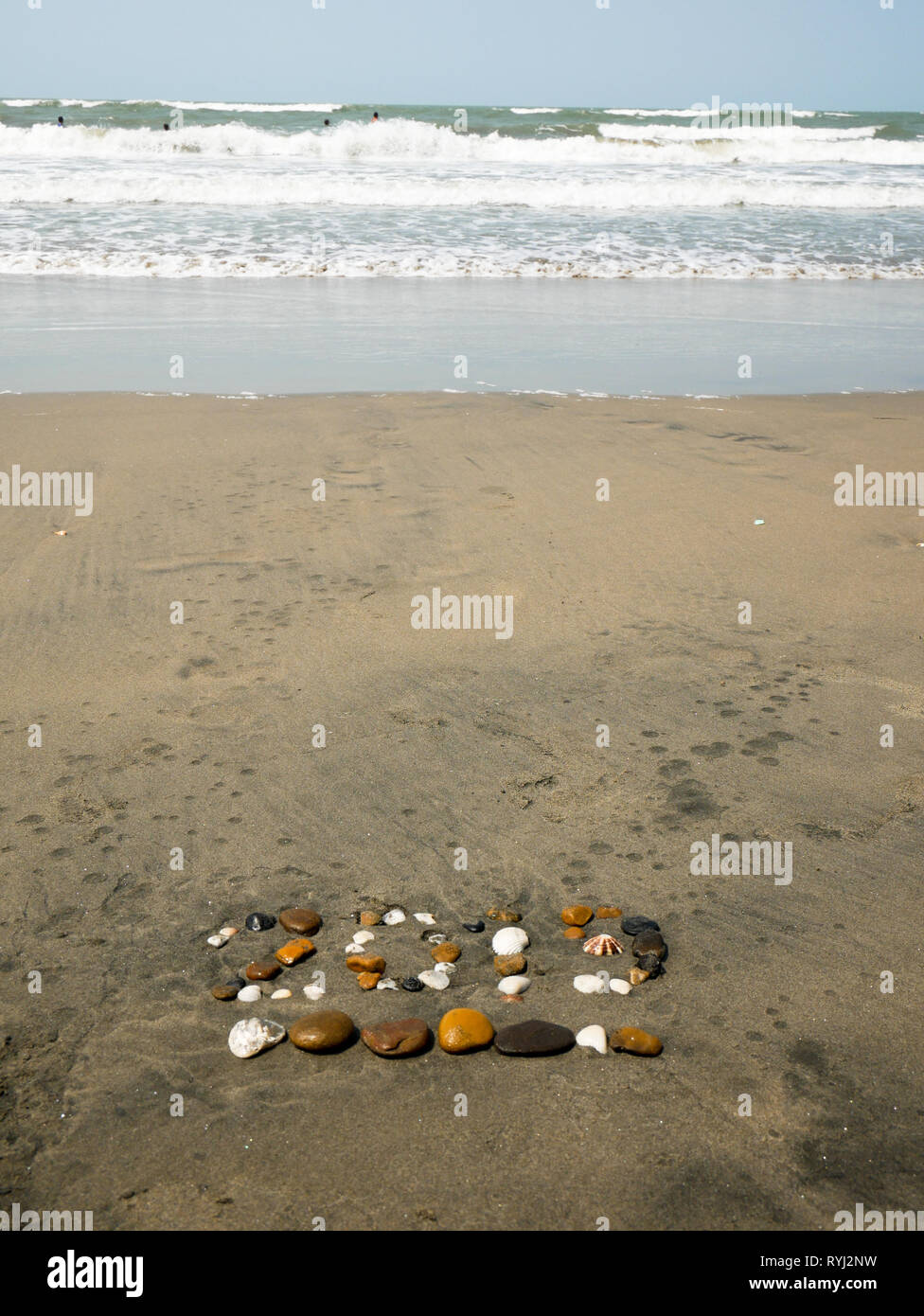 2019 sign made up with pebbles and sea shells on the sea shore of a beach near Cartagena Colombia vertical orientation Stock Photo