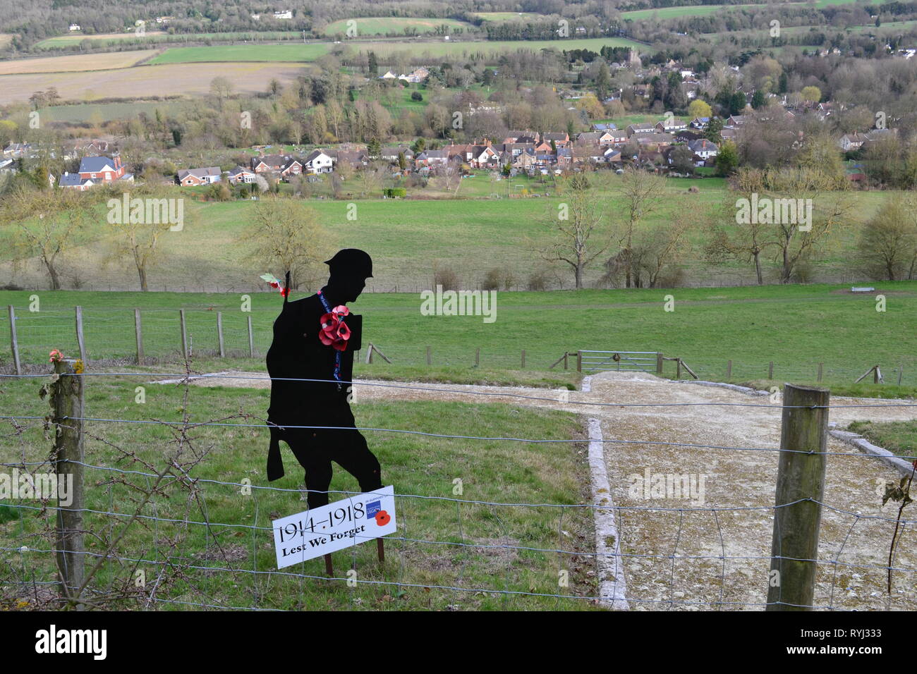 A silhouette of a world war one British soldier next to the 100ft chalk cross on the hillside above Shoreham, Kent, a memorial to 50 villages who died Stock Photo
