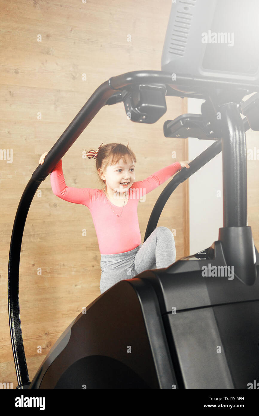 little girl is engaged in the gym on the simulator Stock Photo