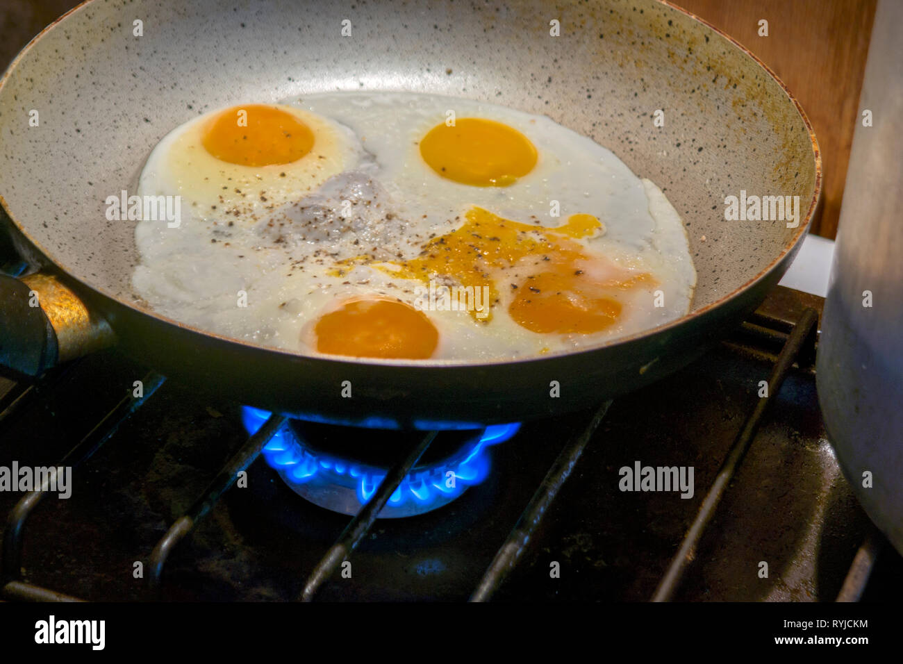 Cooking fried eggs on a gas stove, indoor closep Stock Photo Alamy