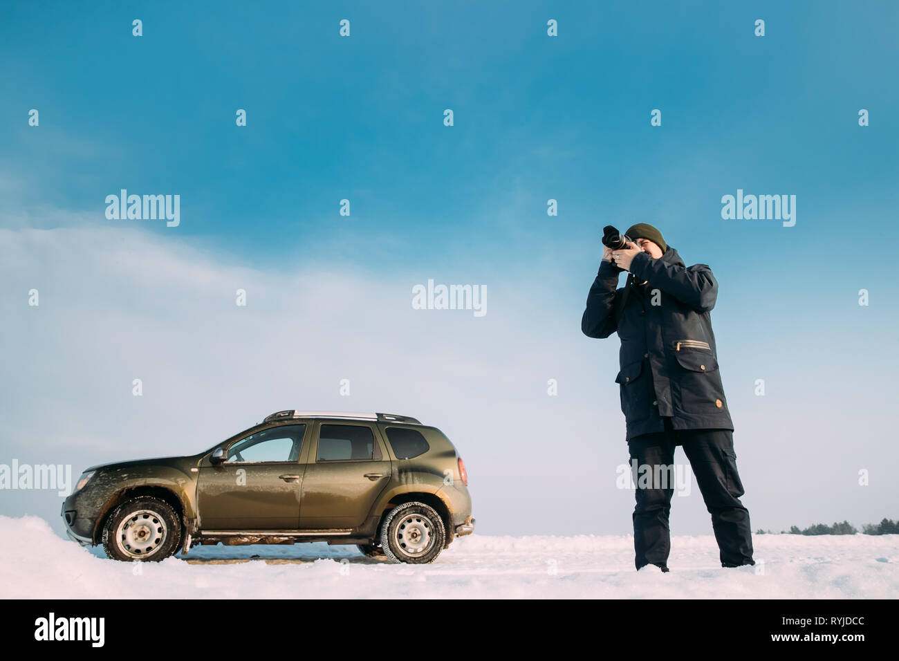 Gomel, Belarus - January 10, 2019: Young Man Taking Photo On Background Of Car Renault Duster Or Dacia Duster Suv Parked On Roadside At Winter Day. Stock Photo