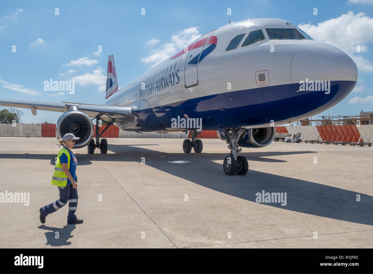 PREVEZA, GREECE - JUNE 10 2018: Ground staff member walking past a Brisitish Airways airplane on Preveza airport tarmac in Greece Stock Photo
