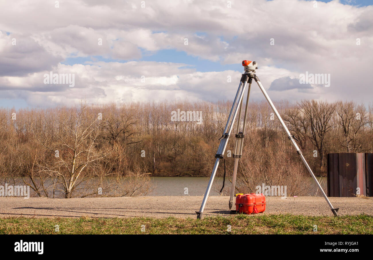 Theodolite level tool on flood protection dam under construction on river Danube. Stock Photo