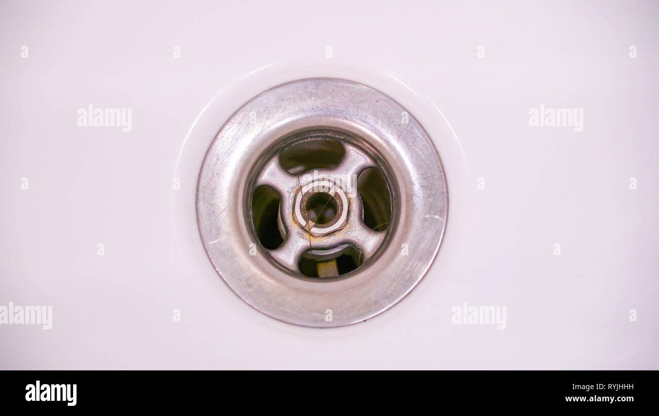 The small hole of the bathtub inside the bathroom where the water is being drained out Stock