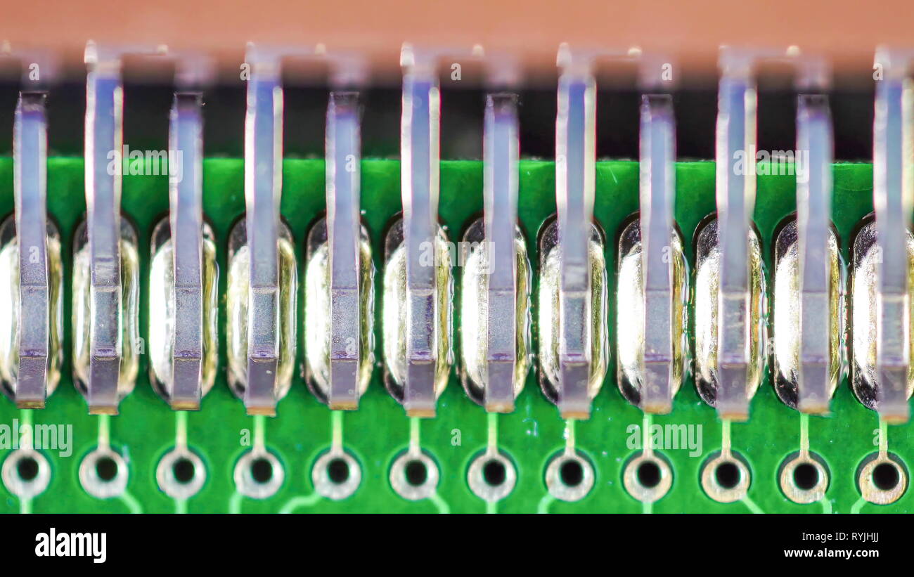 Tiny silver edge parts of the capacitors part on the green colored circuit board used for electronics Stock Photo