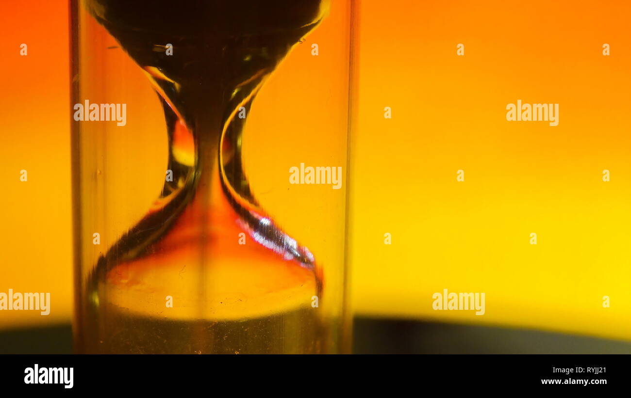 The macro shot of the sand inside the hour glass with the sand dripping so fast Stock Photo