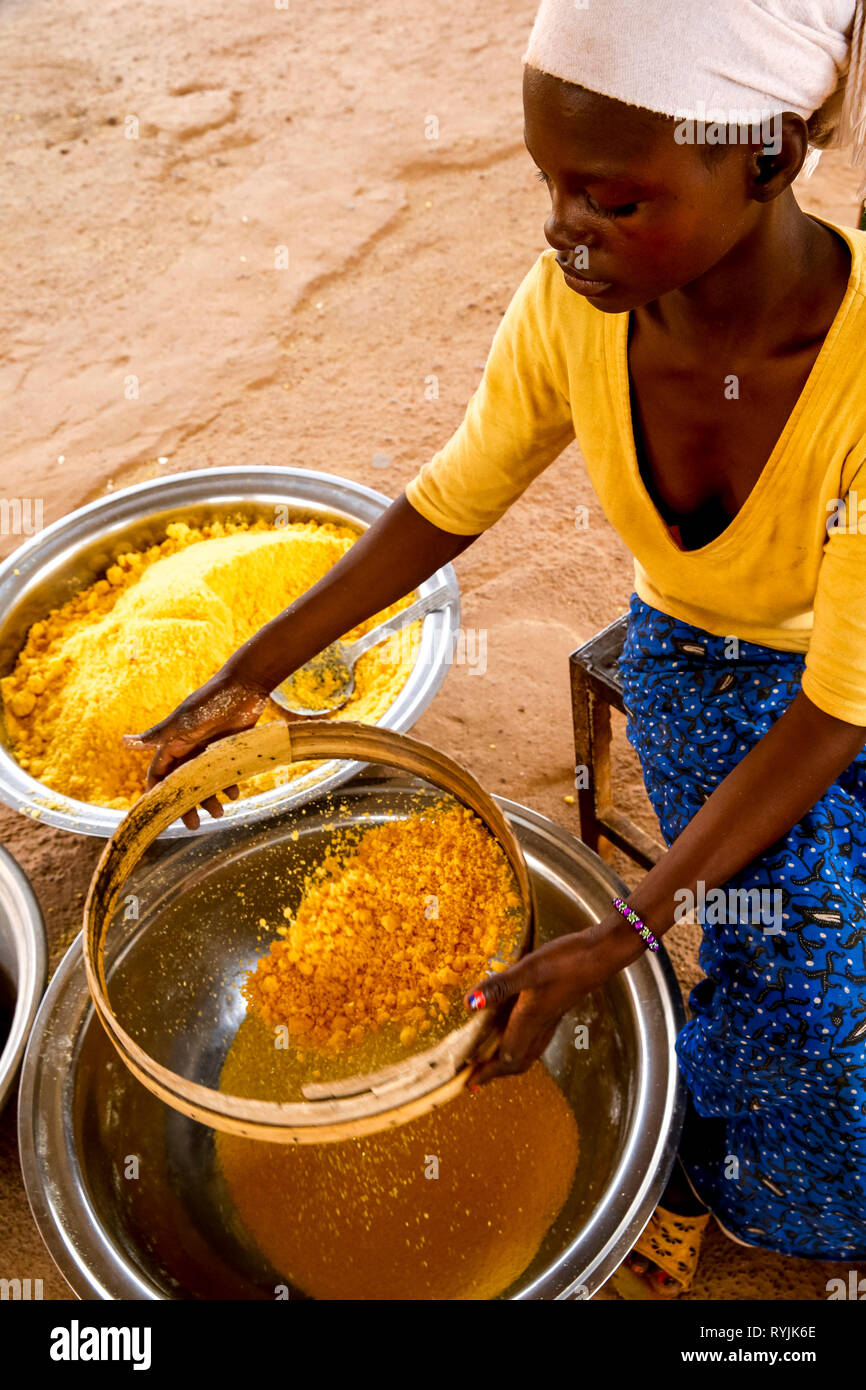 Girl making flour in Koudougou, Burkina Faso. Stock Photo