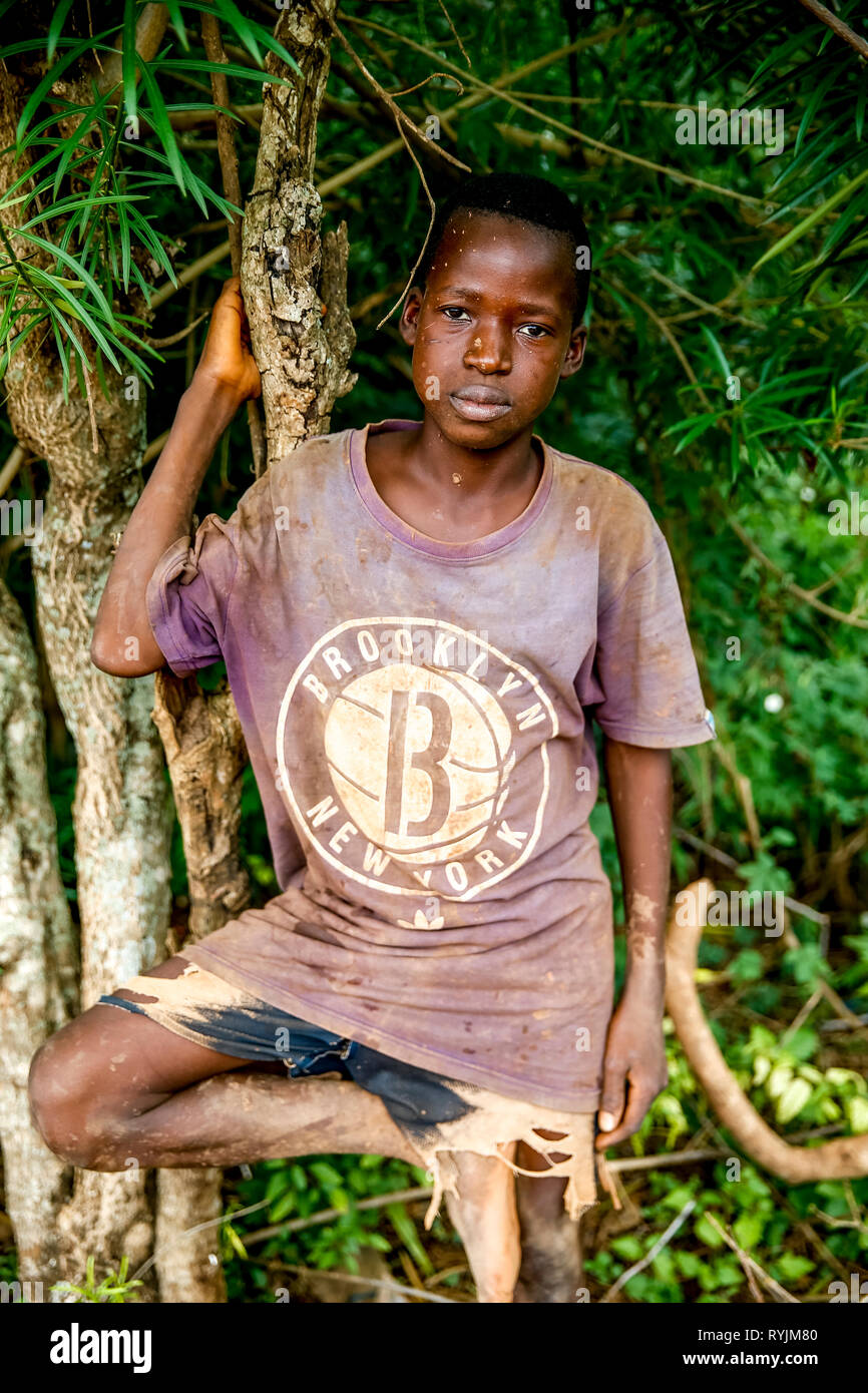 Boy standing against a tree in a rural area near Daloa,  Ivory Coast. Stock Photo