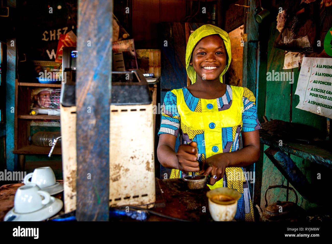Smiling muslim girl working in a cafÃ© near Agboville, Ivory Coast. Stock Photo