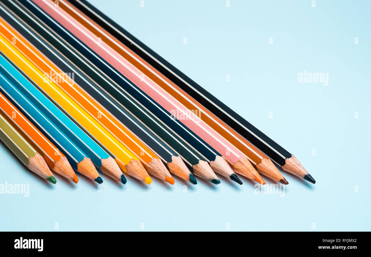 Close-up of colored pencils arranged in a row on a uniform white background with all colors Stock Photo