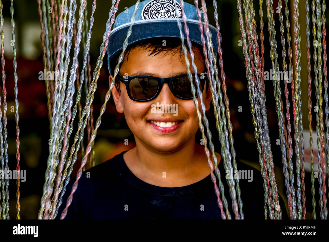 12-year-old boy looking through a shop curtain in Caltagirone, Sicily (Italy). Stock Photo