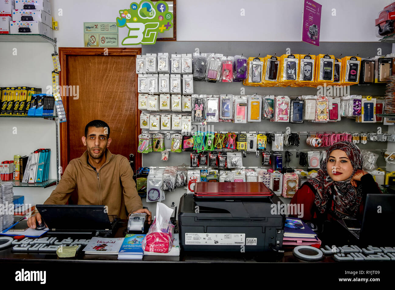 Hareth Elyan and his sister Hanna run a mobile phone accessory shop in Jalazone refugee camp near Ramallah, West Bank, Palestine. They borrowed U.S.$5 Stock Photo