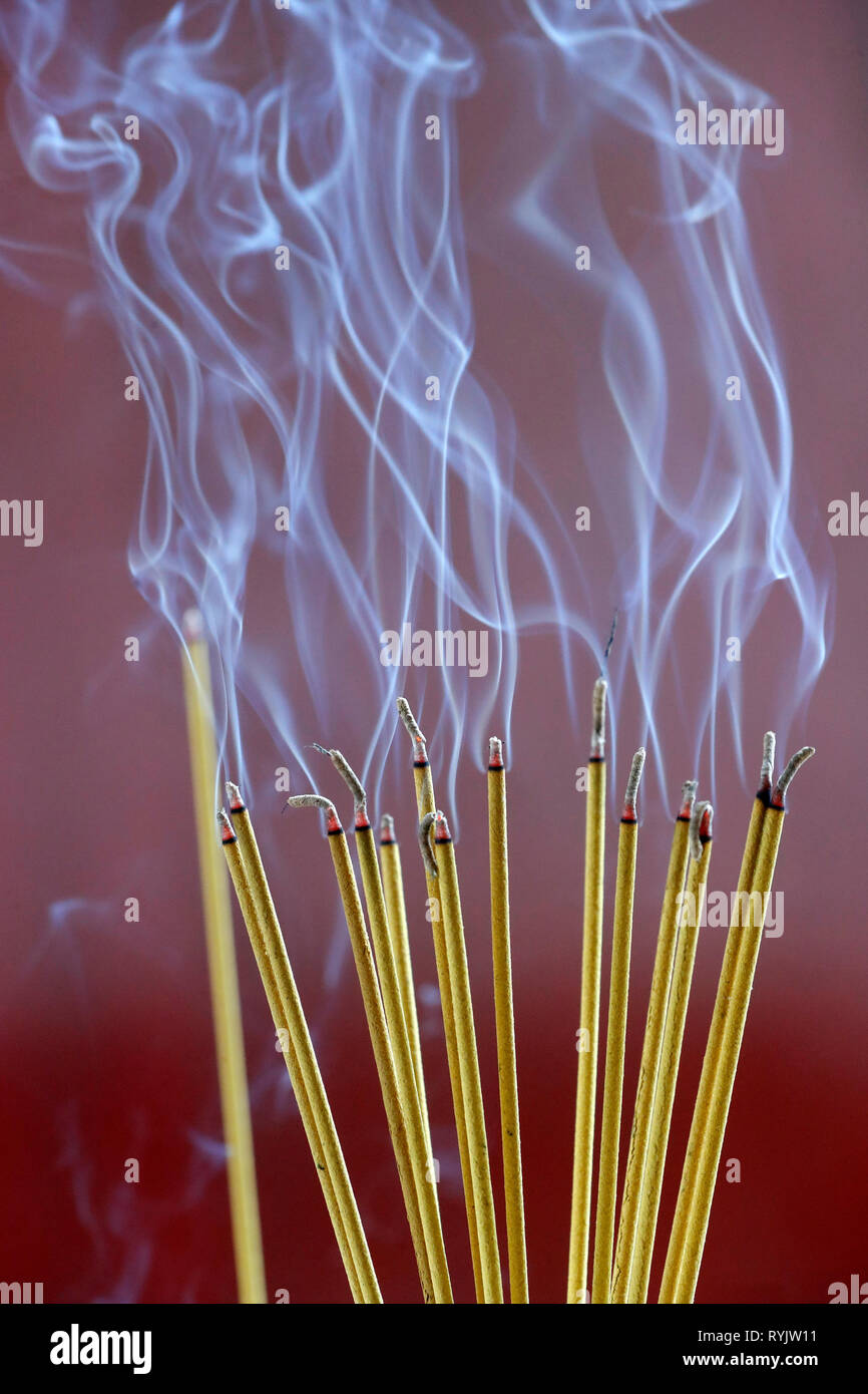 Incense sticks on joss stick pot are burning and smoke use for pay