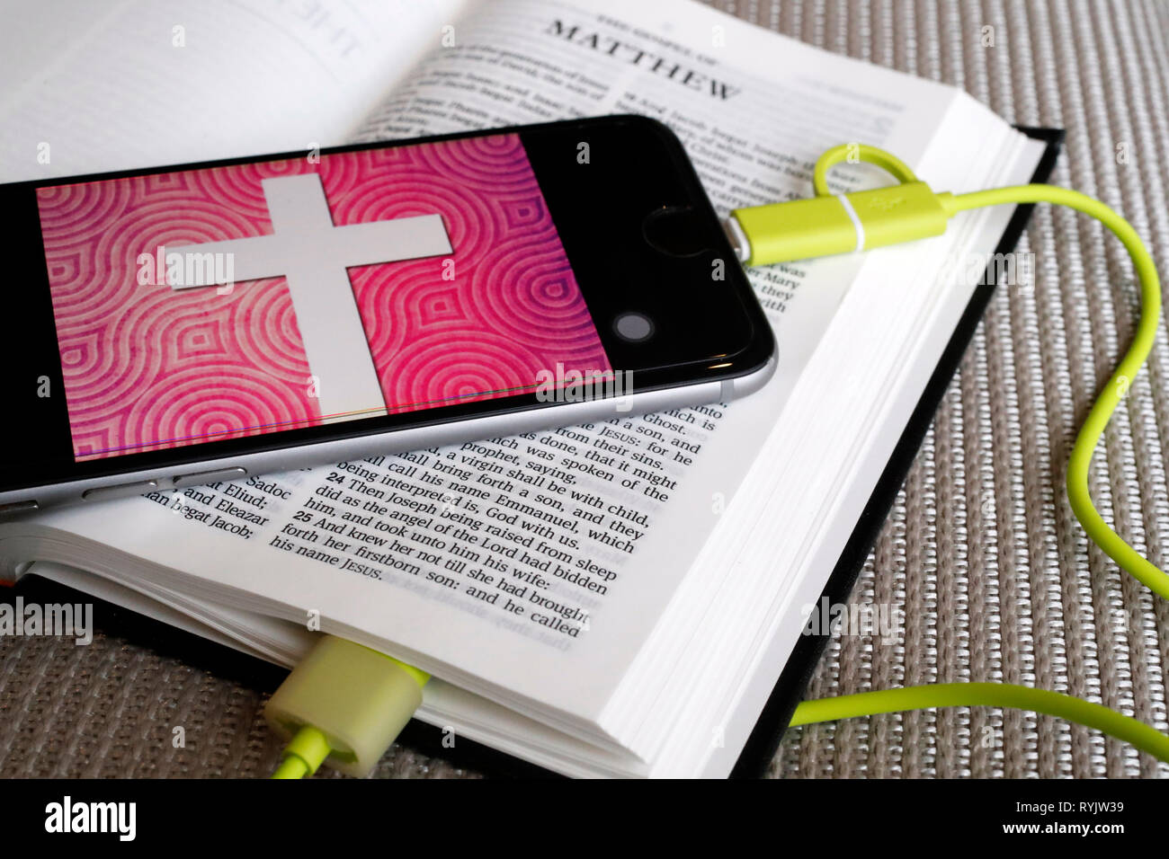 Paper Bible and digital Bible app on smartphone. Stock Photo