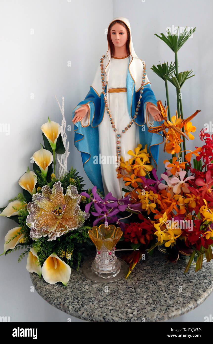 Virgin Mary statue with tropical flowers. Vietnam Stock Photo - Alamy