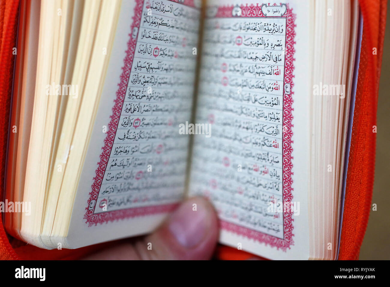 Muslim man reading an Arabic Holy Quran (Koran). Stock Photo