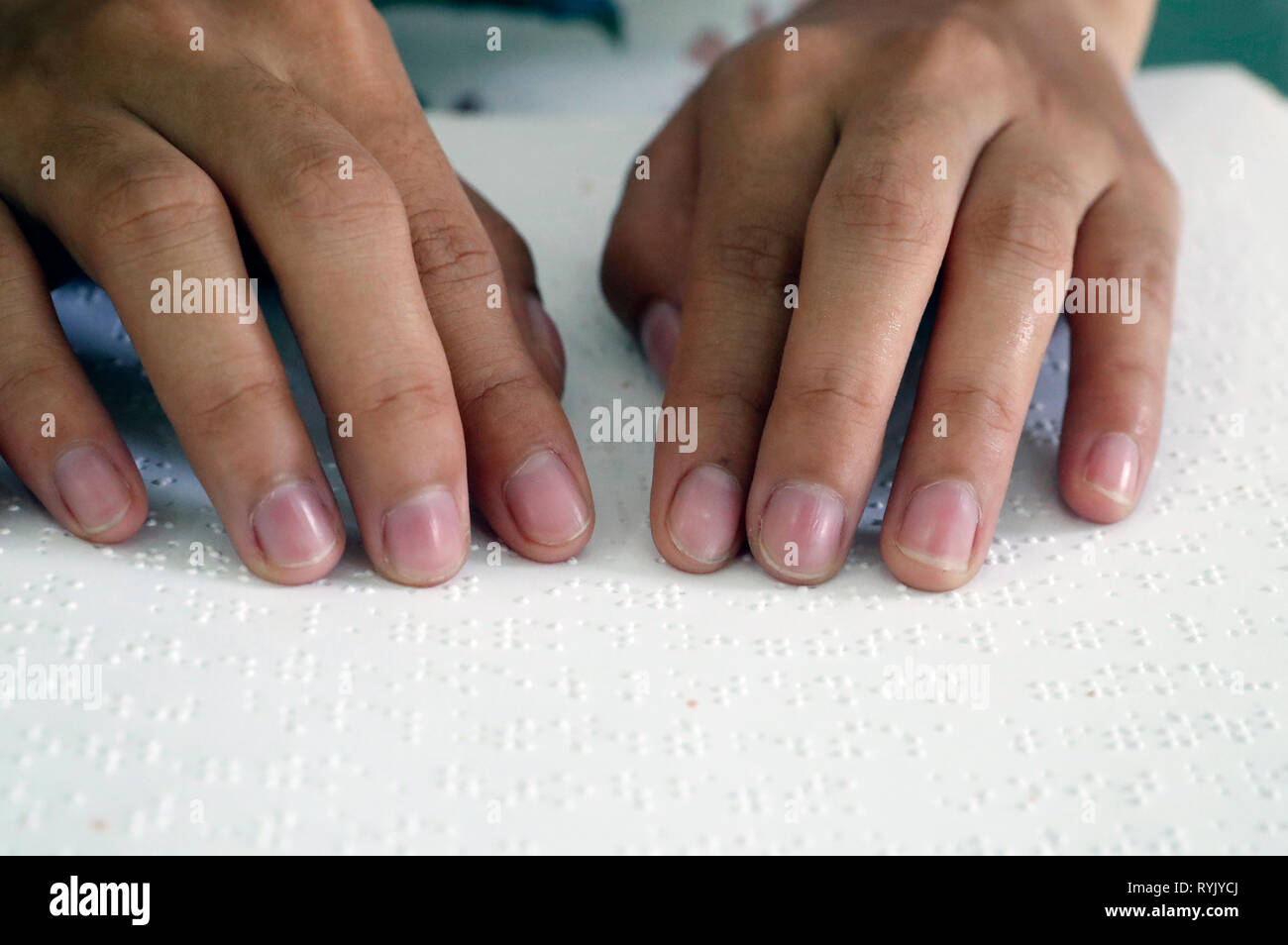 Center for blind children run by Children Action.  Catholic chapel.  Blind girl reading a Braille version of the Bible.  Ho Chi Minh city. Vietnam. Stock Photo