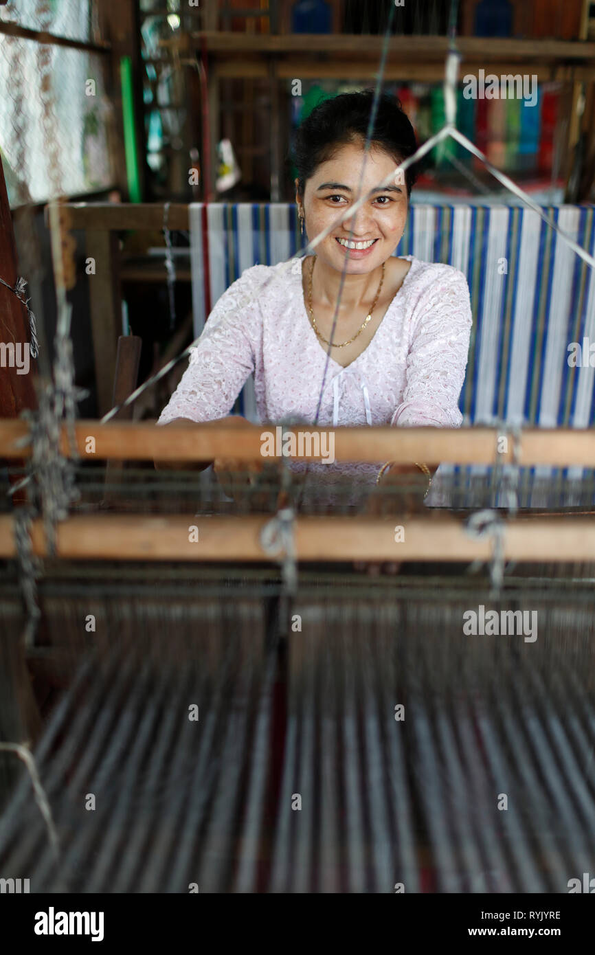 Traditional hand loom.  Local woman diligently weaving colourful scarves.  Chau Doc. Vietnam. Stock Photo