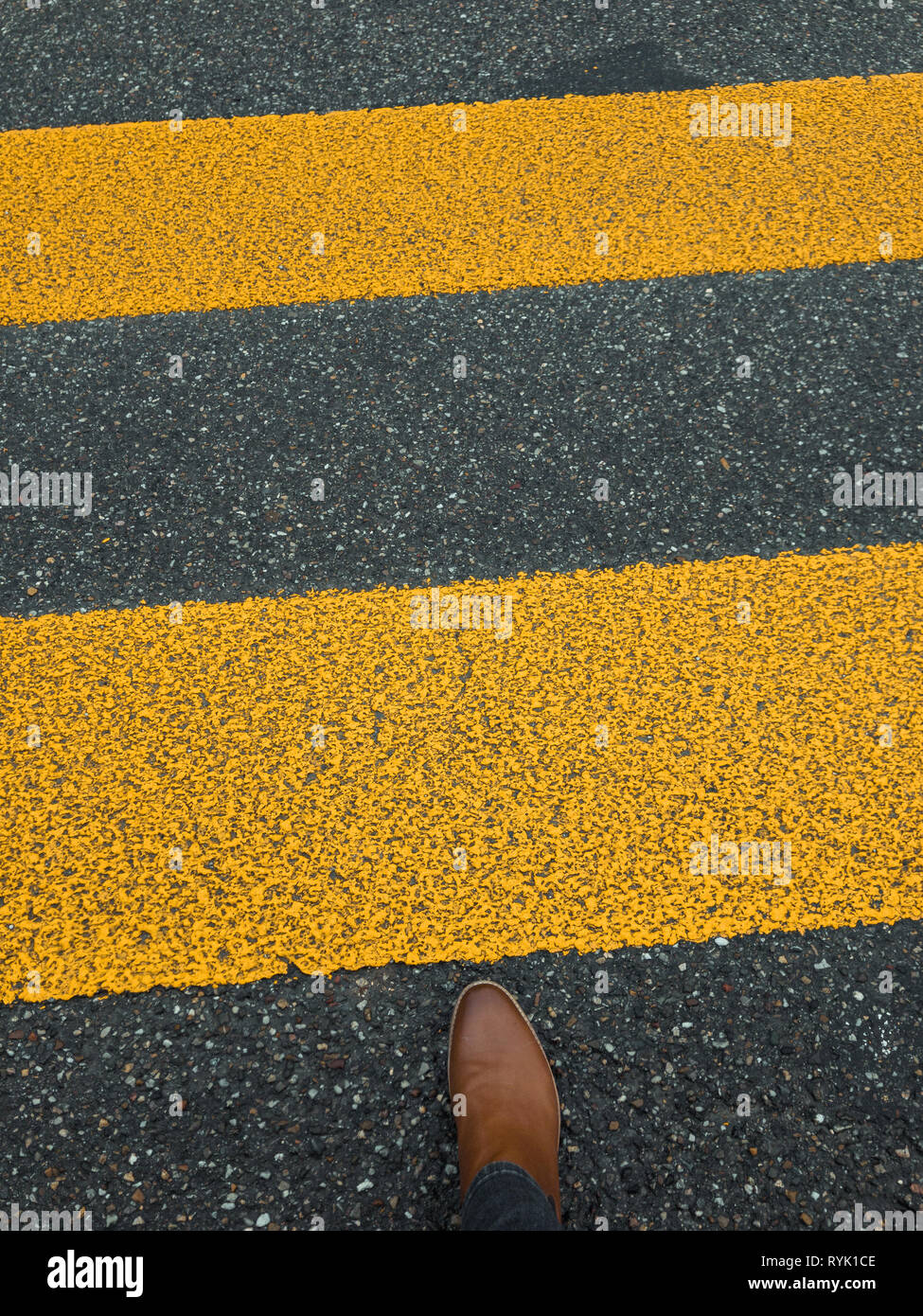 pedestrian stripe on pavement with feet Stock Photo