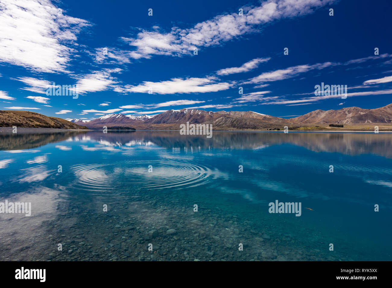 Beautiful Lake Tekapo with reflection of sky and mountains, New Zealand Stock Photo