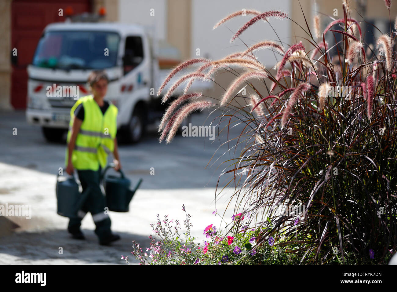 Colourful flowers in the  village of Saint Gervais les Bains in the French Alps.  Gardener watering flowers.  France. Stock Photo