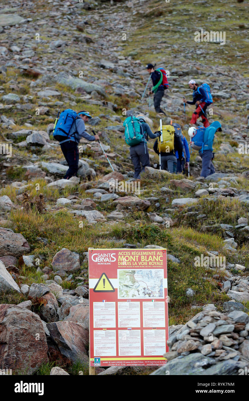 Alpinists during the ascent of Mont Blanc along the regular route via Gouter Refuge.  Local Bye-Law. Regulated Access to Mont Blanc sign.   France. Stock Photo