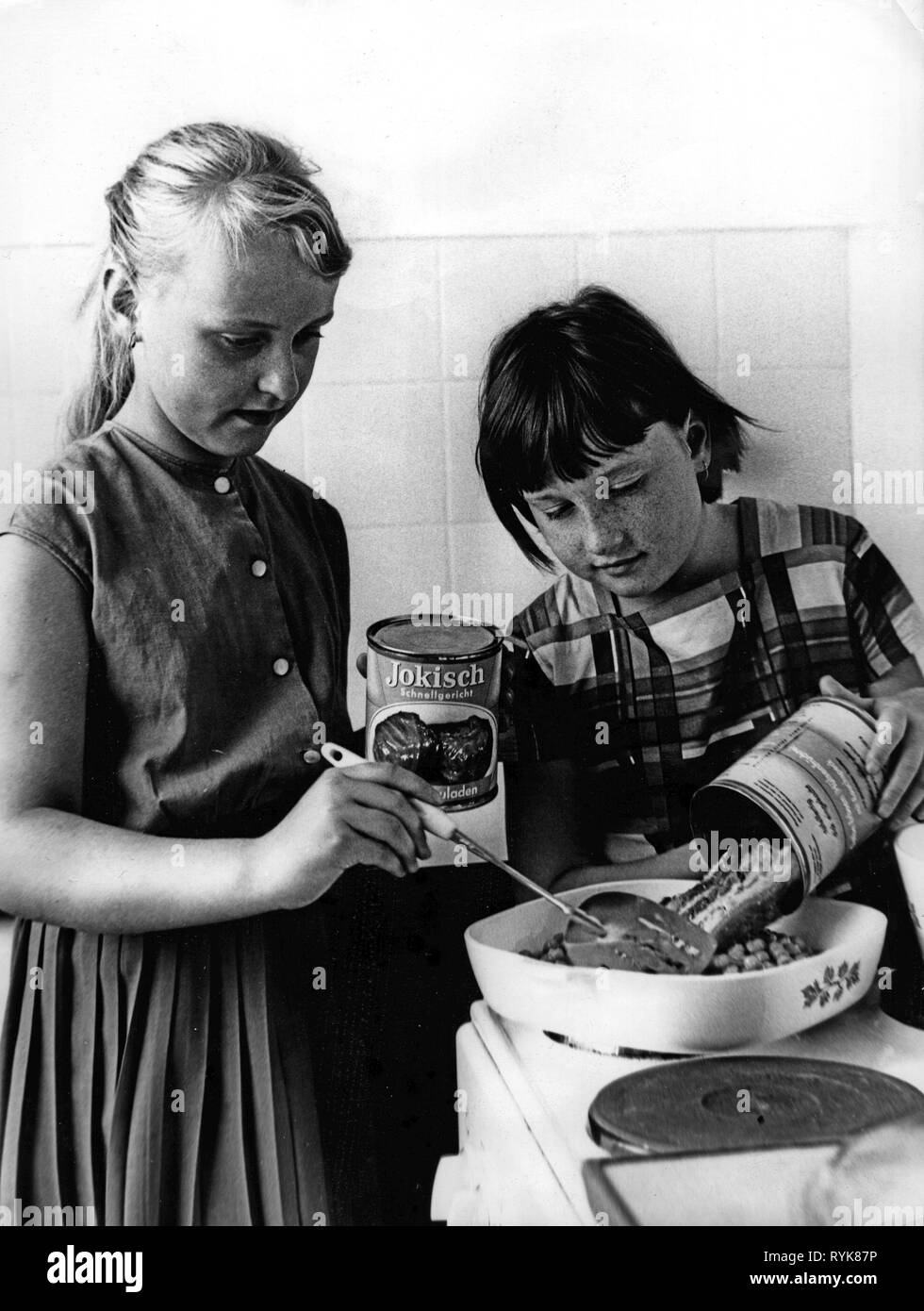 household, cooking and baking, two children preparing meal made of tinned food, 1960s, half-length, half length, standing, kitchen, kitchens, electric cooker, electric cookers, hob, stove top, stovetop, bowl, bowls, fill, filling, spatula, pea stew, stew, olla podrida, hotpot, hot pot, stuffed cabbage leaves, stuffed cabbage leavess, Jokisch, quick lunch, quick lunches, diet, stove, stoves, tins, cans, preserve, preservered food, tin, can, nutrition, household, households, cook, cooking, bake, baking, children, child, kids, kid, prepare, preparin, Additional-Rights-Clearance-Info-Not-Available Stock Photo