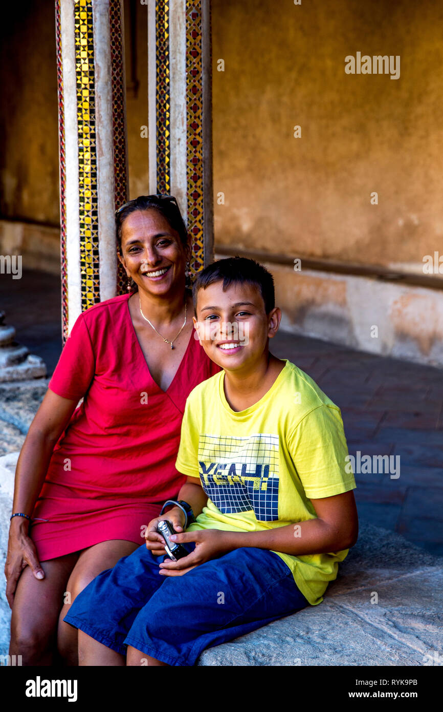 12-year-old boy sitting with his mother in the cloister of Monreale cathedral, Sicily (Italy). Stock Photo