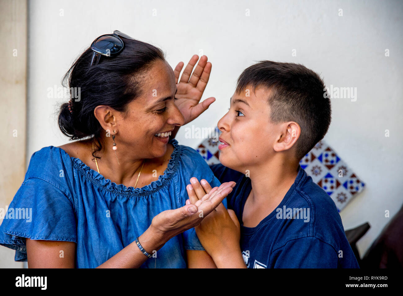 Smiling mother and son playing a game in Taormina, Sicily (Italy). Stock Photo
