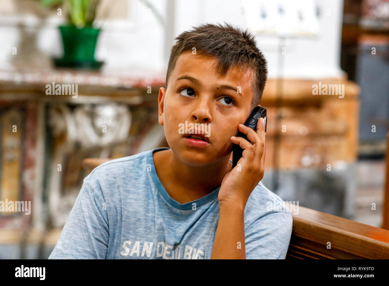 12-year-old boy using an audioguide in a church in Catania, Sicily (Italy). Stock Photo