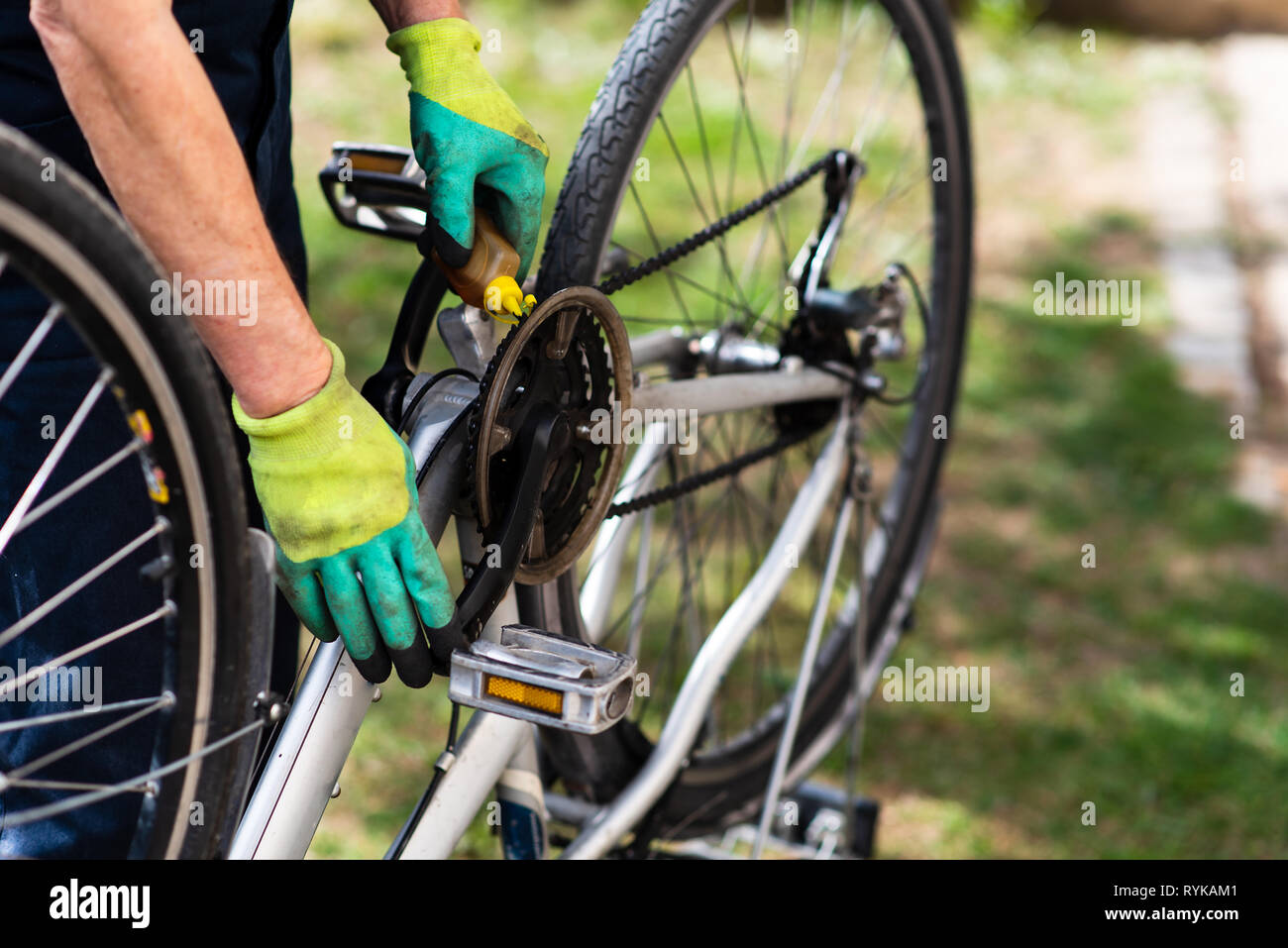 Man lubricating bicycle chain and maintaining for the new season Stock Photo