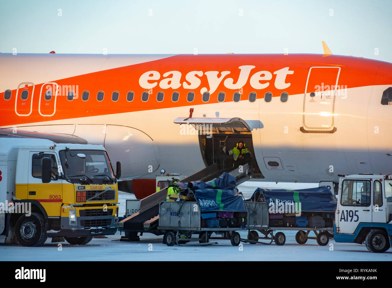 Airport workers removing the luggage bags from an easyJet aeroplane, Kittila airport sign, Kitilla, Finland. Stock Photo
