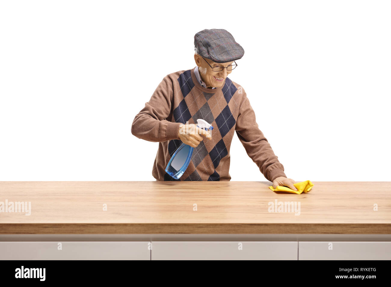 Elderly man cleaning a wooden counter isolated on white background Stock Photo