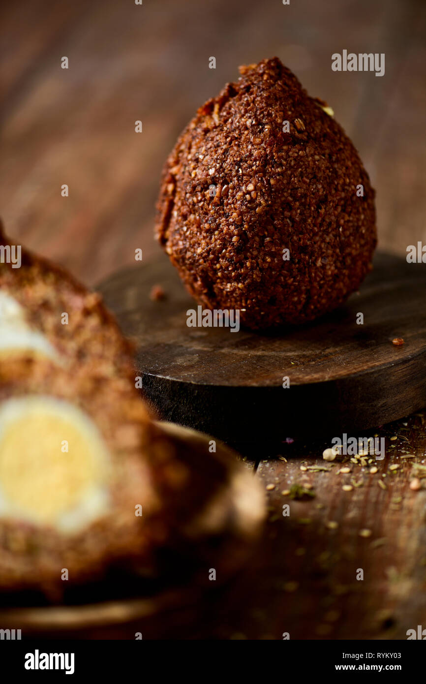some kibbeh, a levantine dish, made of bulgur, onion, minced meat and different spices, on a rustic wooden table Stock Photo