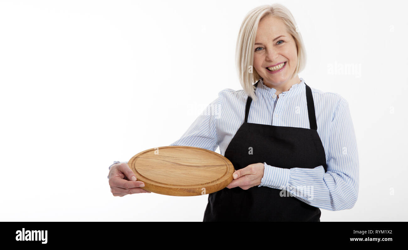 attractive woman waitress gives empty pizza board for your advertising products isolated on white background. Mock up for use Stock Photo