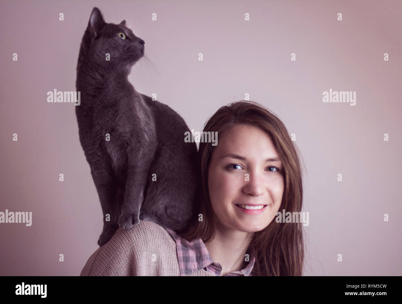 Woman with her funny pet cat sitting on her shoulders Stock Photo
